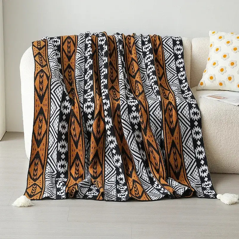 A cozy decorbites bohemian winter blanket in burnt orange white with bold geometric pattern and tassels for bedroom decor