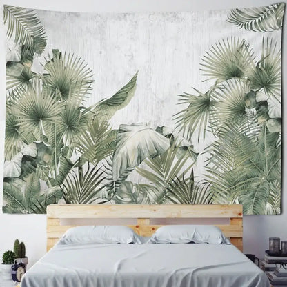 A boho banana tree mist tapestry wall hanging featuring lush green tropical leaves above a wooden bed frame
