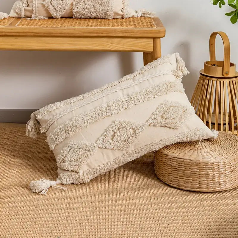 Cream-colored rectangular cushion cover with geometric embroidery and fringed tassels in decorbites beige boho style