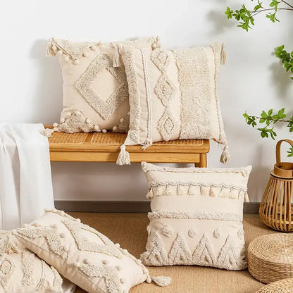 Cream-colored tufted fringed geometric pillow cover with tassels and pom-poms for boho living room decor