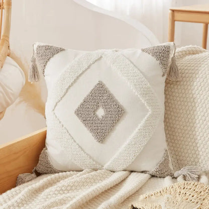 Cream-colored tufted tassel cushion cover with textured gray diamond pattern and tassels for living room decor