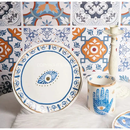 White ceramic eyes ceramic dinner plate with blue and gold bright eyes decorbites motif and decorative borders