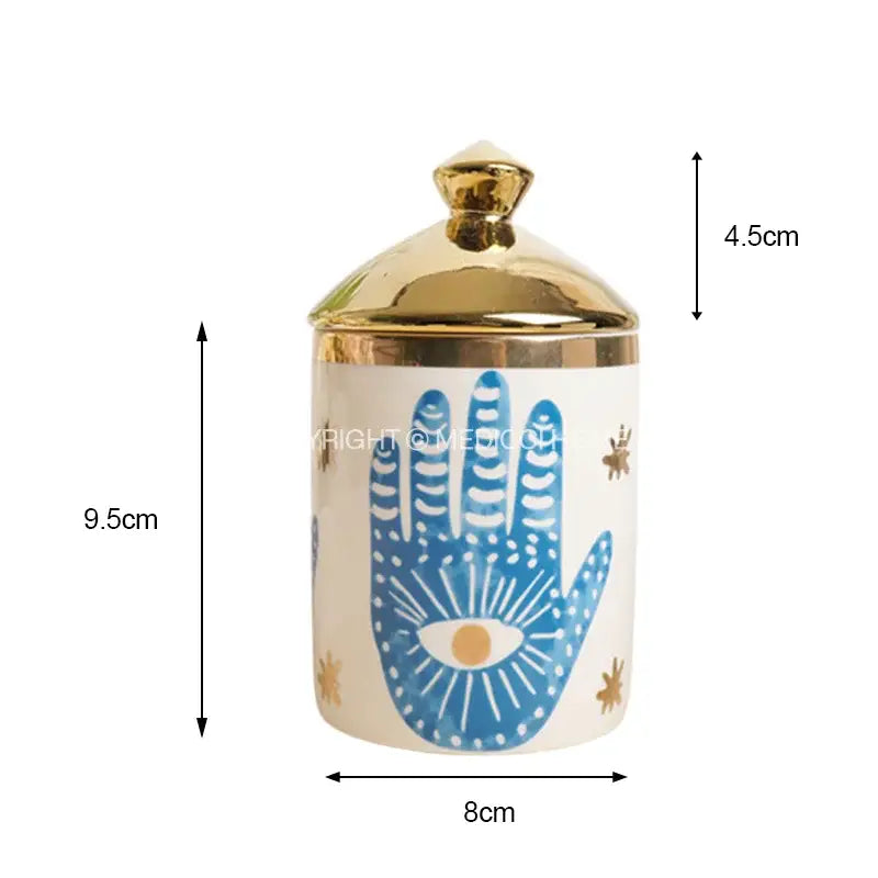 A white ceramic jar with a gold lid and blue hamsa hand design for decorbites bright eyes ceramic dinner use