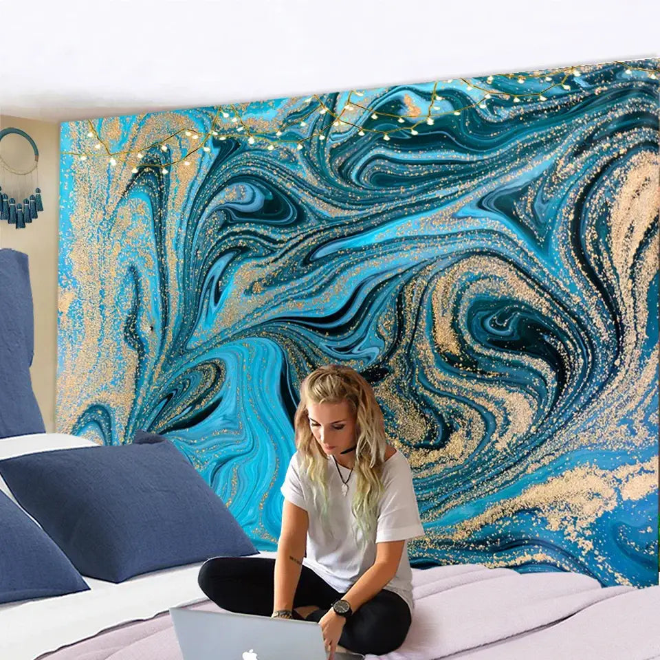 Vibrant blue gouache line and gold marbled tapestry with glittery swirls hanging on a bedroom wall