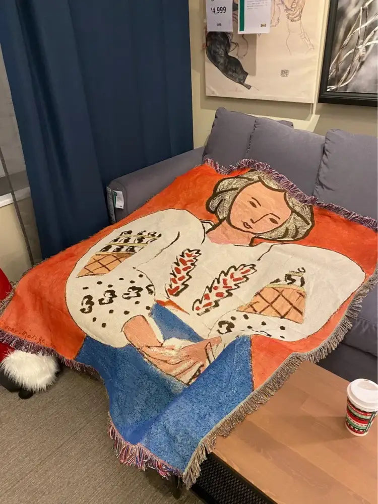 Decorbites boho chic throw blanket featuring an orange and blue woven design with stylized woman and leopard print accents