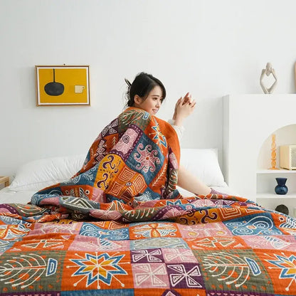 A cozy decorbites boho cotton blanket with vibrant orange blue and purple patchwork geometric patterns in a bright bedroom