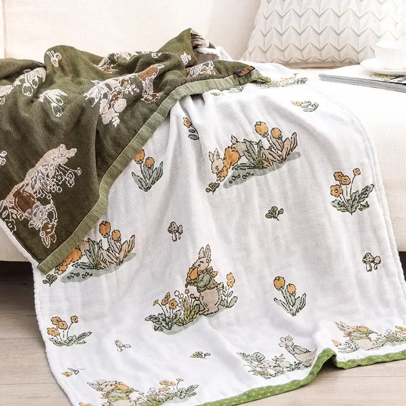Olive green and white plush blanket with embroidered rabbits flowers and mushrooms paired with decorbites boho cotton gauze bath towel beige and blue paisley bathroom wrap