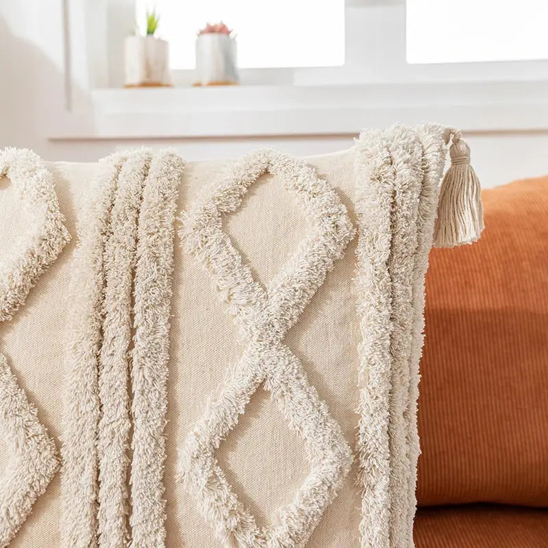 Cream-colored textured cotton pillow cover with diamond-patterned fringe and boho cotton tassel decorbites boho cotton tassel