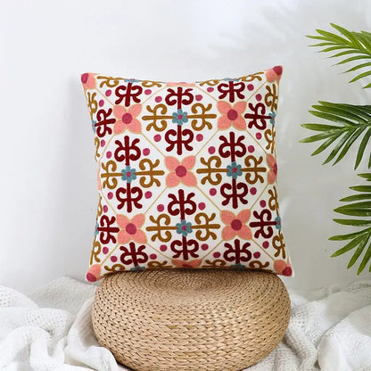 A square boho farmhouse floral cream embroidered pillow cover with vibrant pink red flowers and gold teal details by decorbites