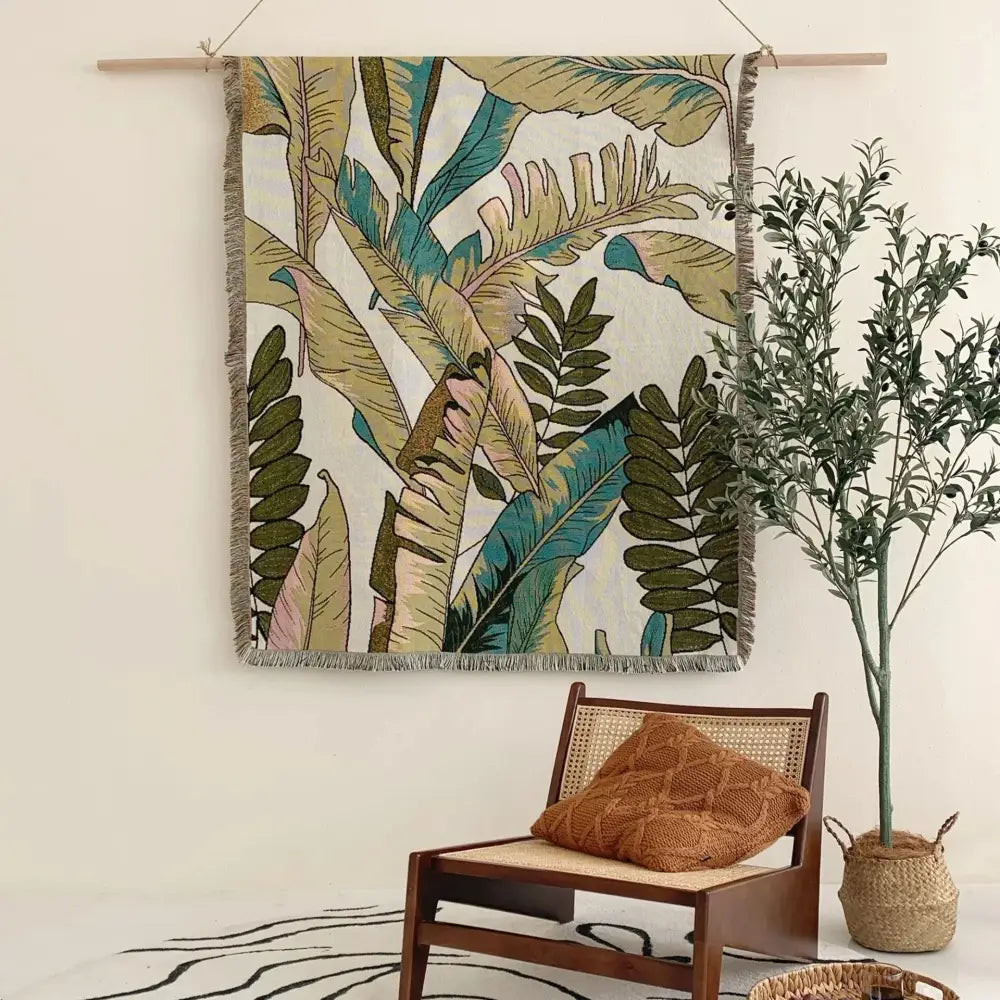 A decorbites boho floral cotton blanket with a teal olive green tropical leaf pattern and fringed edges for living room decor