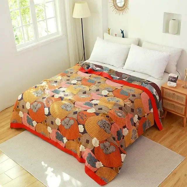 Boho floral cotton gauze leisure blanket featuring a vibrant orange persimmon design with red trim on dark background