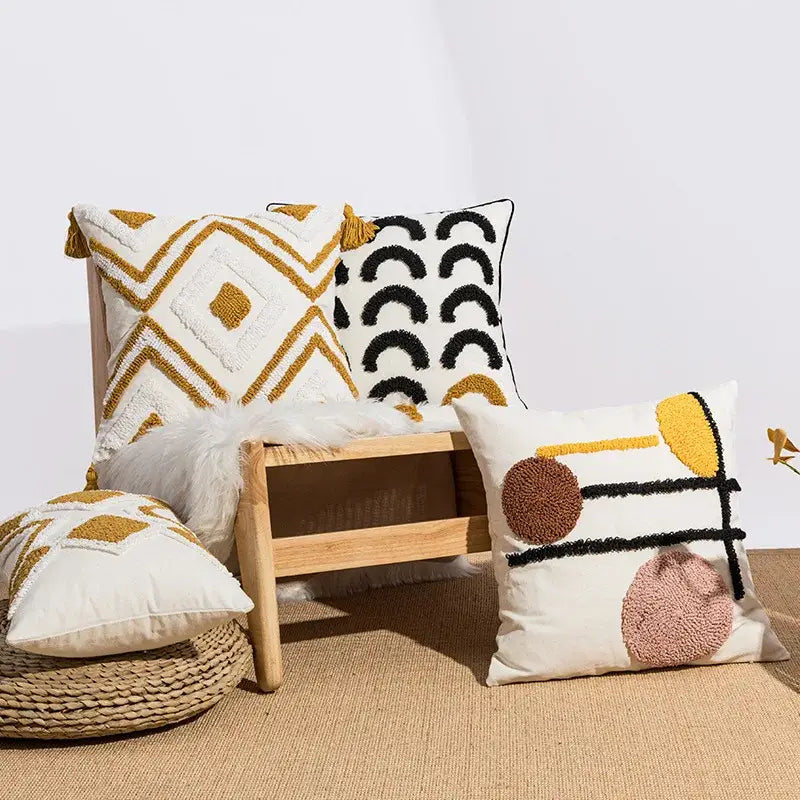 Cream-colored cushion cover with decorbites geometric embroidery in mustard yellow black brown and pink yarn for boho decor