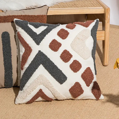 Cream-colored cushion cover with decorbites geometric embroidery in brown and gray yarn for boho living room decor