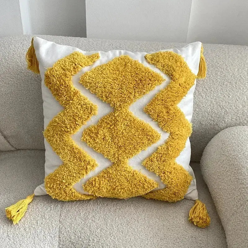 A vibrant yellow and white boho geometric tufted pillow cover with textured fabric and fluffy tassels for living room decorbites set