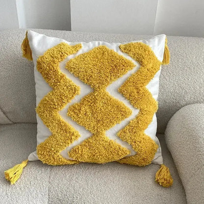 A vibrant yellow and white boho geometric tufted pillow cover with textured fabric and fluffy tassels for living room decorbites set