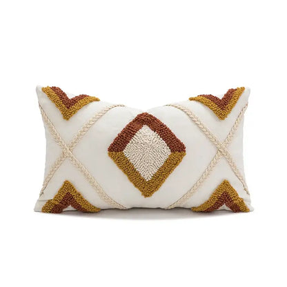 Cream-colored boho loop tufted geometric pillow cover with rust and mustard textured patterns and braided rope accents