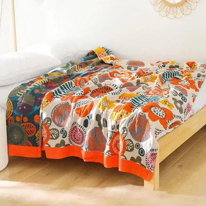 A vibrant boho mandala cotton summer blanket with bold orange teal floral motifs and orange hem for decorbites throw
