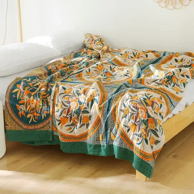 A cozy boho mandala cotton summer blanket with vibrant orange and green floral motifs on cream background