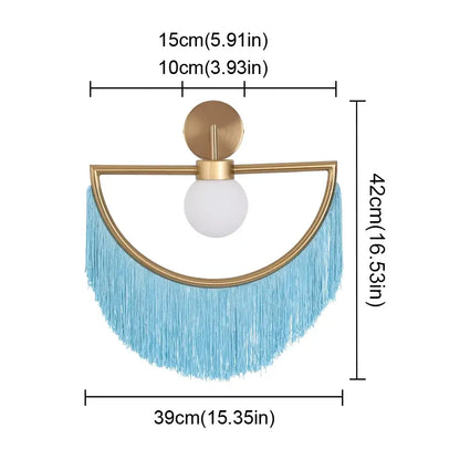A modern gold-toned ball pendant light with a white glass ball and light blue fringe for bedroom use