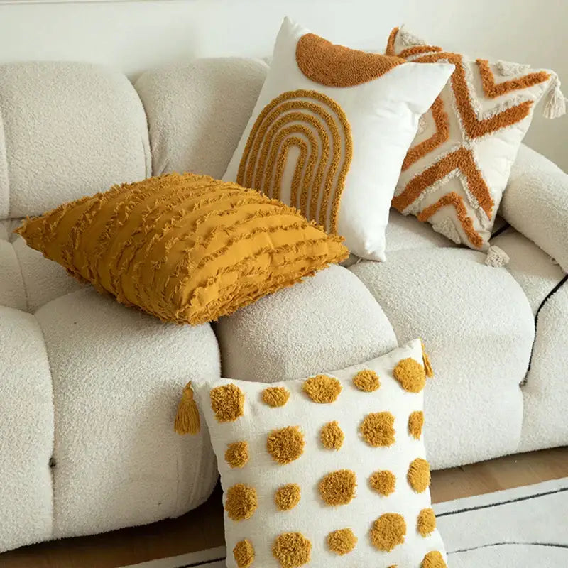 A cozy mustard yellow boho cushion cover with textured frayed edge and decorbites geometric tufted pom pom accents