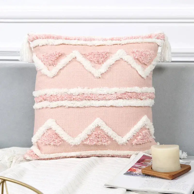 A soft pink boho pink geometric pillow cover with white patterns and tassels for bedroom decorbites decor