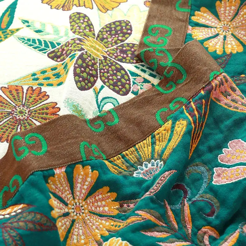 Boho teal floral cotton cover throw blanket with gold embroidery and brown trim featuring green interlocking g logos