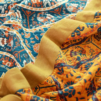 Cozy quilted throw blanket with vibrant blue and mustard-yellow cotton boho manta featuring embroidered animals and foliage