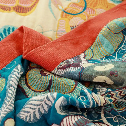 A vibrant teal and coral decorbites cotton boho throw blanket with white gold and brown floral embroidery for bedroom decor