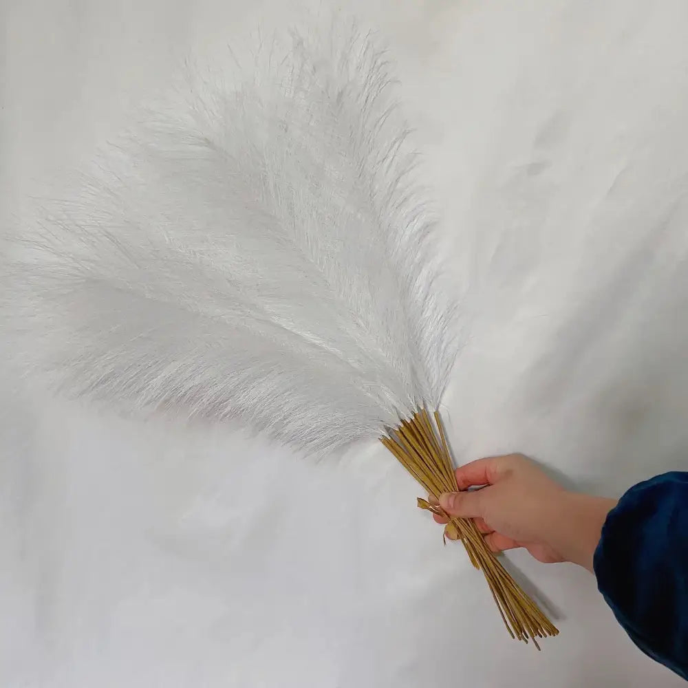 A bundle of white and beige fluffy pampas grass with slender golden stems for living room decor by decorbites