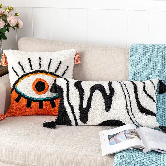 White fluffy throw pillow cover with black abstract eye embroidery and orange black tassels for living room decorbites decor