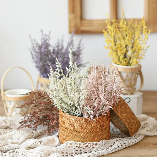 A woven boho wicker basket with a lid filled with pink and white decorbites forever dancing grass flowers