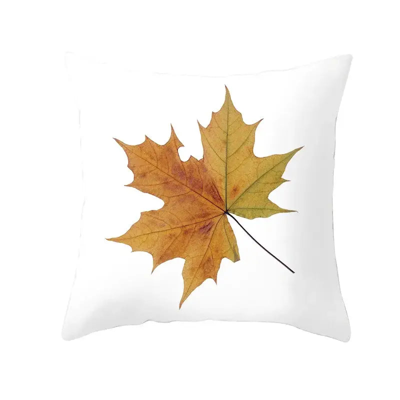 White throw pillow with golden-yellow autumn maple leaves print and subtle brown and green gradients for living room decor