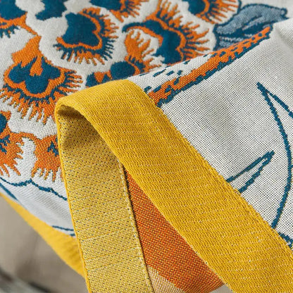 Botanical blue and orange cotton gauze bath towel with vibrant floral pattern and textured yellow fabric edge for bathroom use