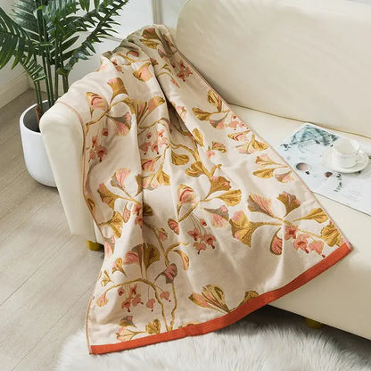 A soft cream-colored decorbites cotton gauze bath towel with floral pattern and orange border for bathroom use
