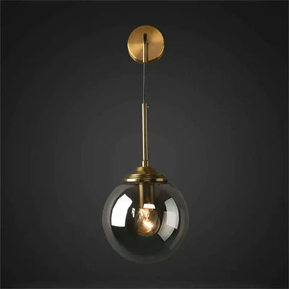 A brass amber glass ball wall light with a sleek brass finish and smoked glass globe for bedroom and living room decorbites glass ball