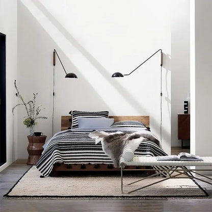 Black articulated wall lamp with adjustable metal wood arms and dome-shaped shades for bedroom reading light