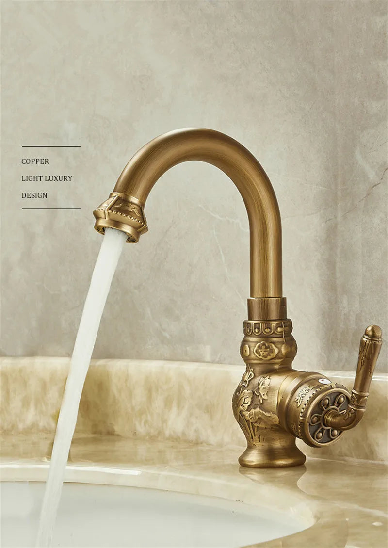 Brass antique bathroom sink faucet with an antique brass finish and ornate floral and scrollwork detailing