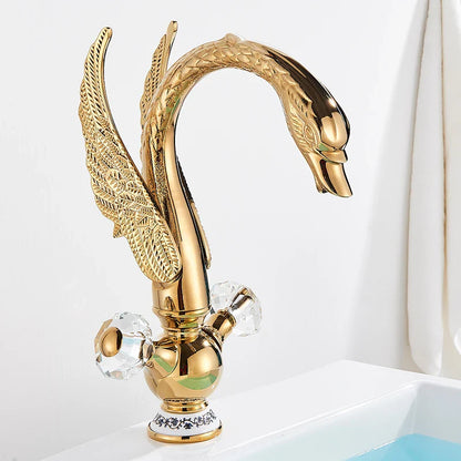 Brass basin faucet deck mounted featuring an antique brass golden swan shape with intricate feather detailing and crystal knobs