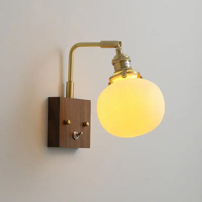Brass ceramic ball led wall light with yellow glowing globe glass lamp brass arm and wooden base for living room