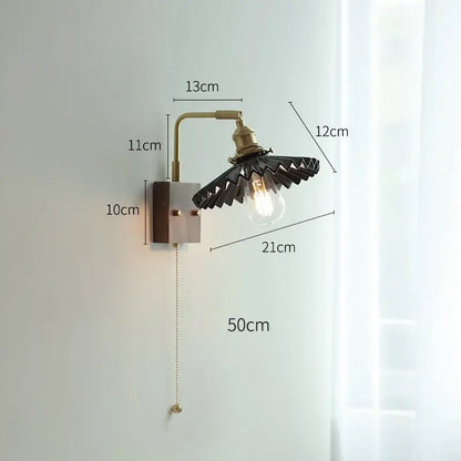 Industrial-style led wall light with brass-finished metal arm and black fan-shaped shade for living room use