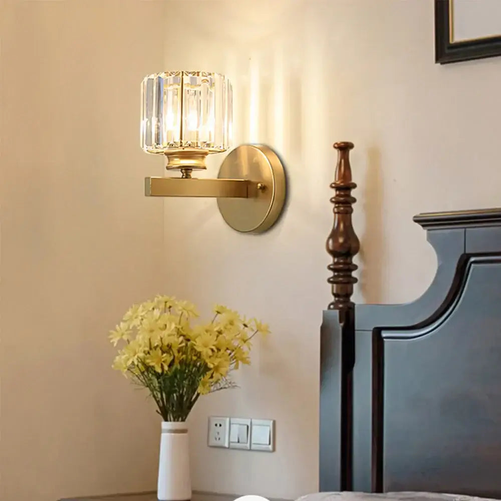 Brass-finished wall sconce with faceted decorbites crystal glass shade for elegant bedroom lighting decor