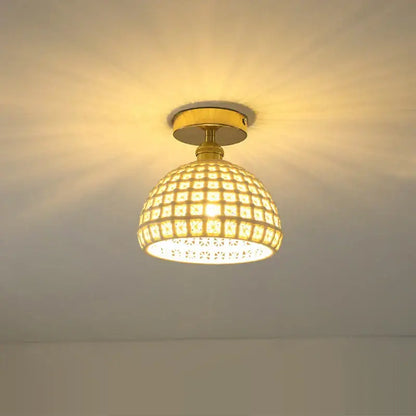 A warm-toned glass shade pendant ceiling lamp with brass finish and intricate mosaic tiles for kitchen lights