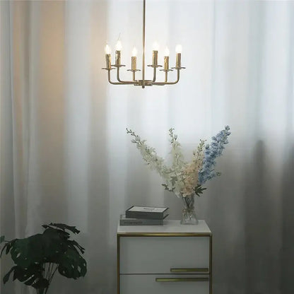Gold-toned brass iron art chandelier lights with six candle-style bulbs for dining room decor by decorbites iron art