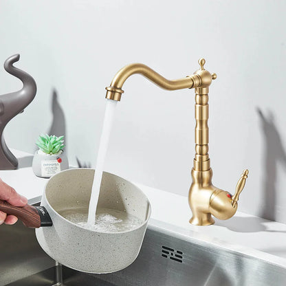 Brass kitchen faucet deck mounted with rotating neck curved spout and ornate segmented body design in brass finish
