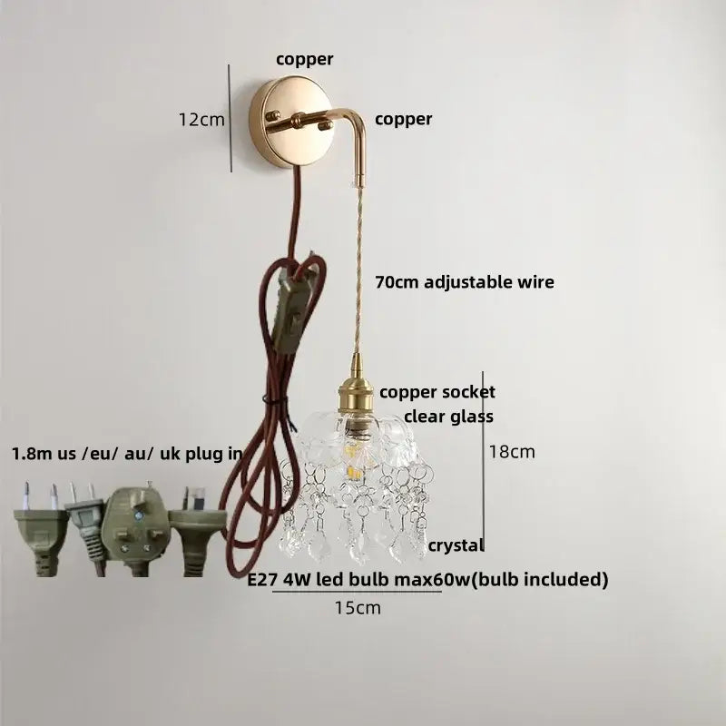 A delicate copper-finished wall light with clear glass shade and dangling crystals featuring an adjustable led wire