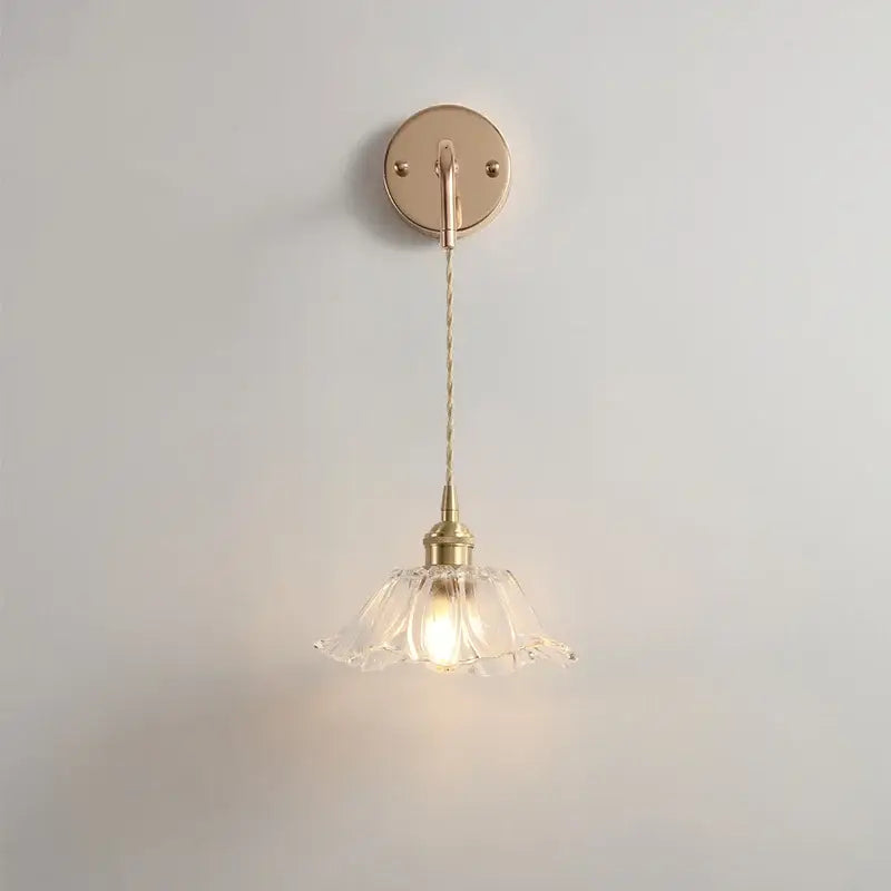 A delicate brass petal glass decorbites adjustable led wall light with a fluted shade and twisted cord