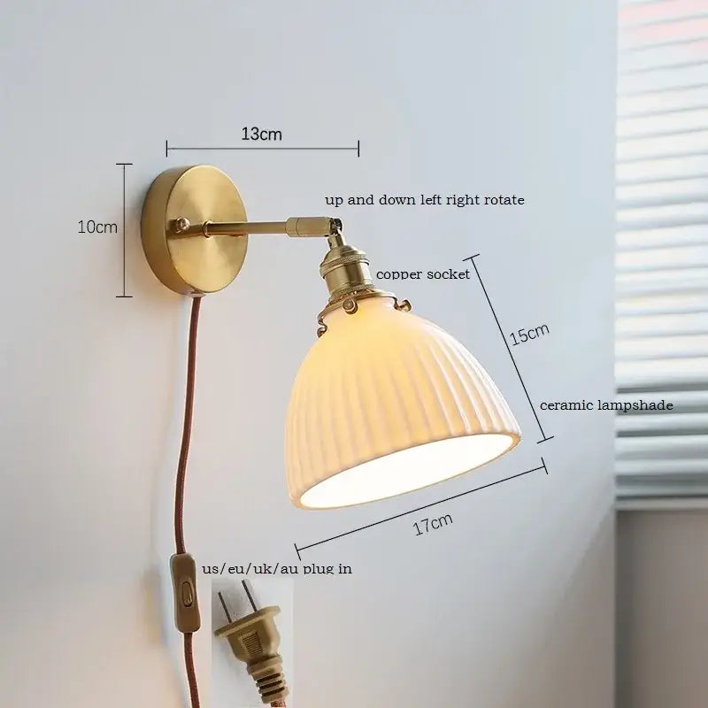 Brass ribbed decorbites ceramic wall sconce with iron arm featuring brass finish and off-white ribbed ceramic shade