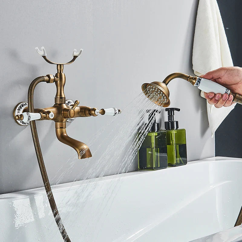 Antique brass shower faucet wall mount with white ceramic handles and handheld showerhead for cold water control