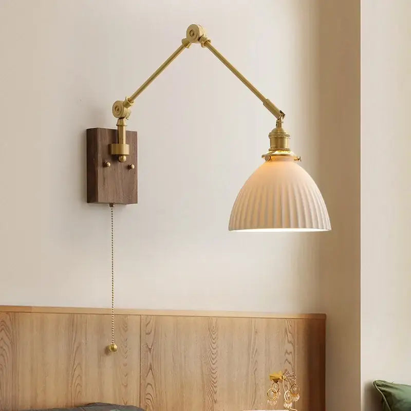 Brass adjustable wall sconce with cream ribbed glass shade and wooden mount featuring copper swing arm led design