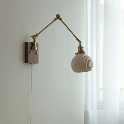 Brass walnut wall light with a cream ribbed glass shade and brass articulated arm for bedroom decorbites ceramic ball design